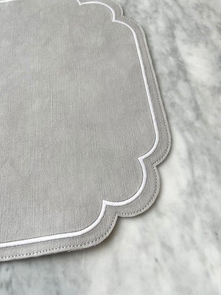 Gray placemat with scalloped edge on a marble surface