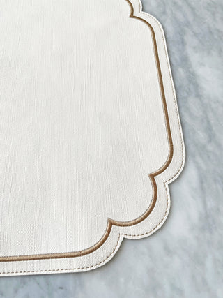 White placemat with scalloped edge on a marble surface